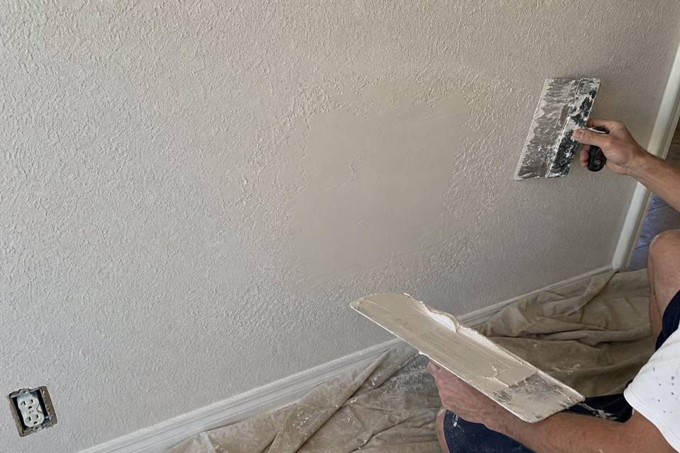 Texture matching and drywall patch repair in progress for Orlando drywall projects